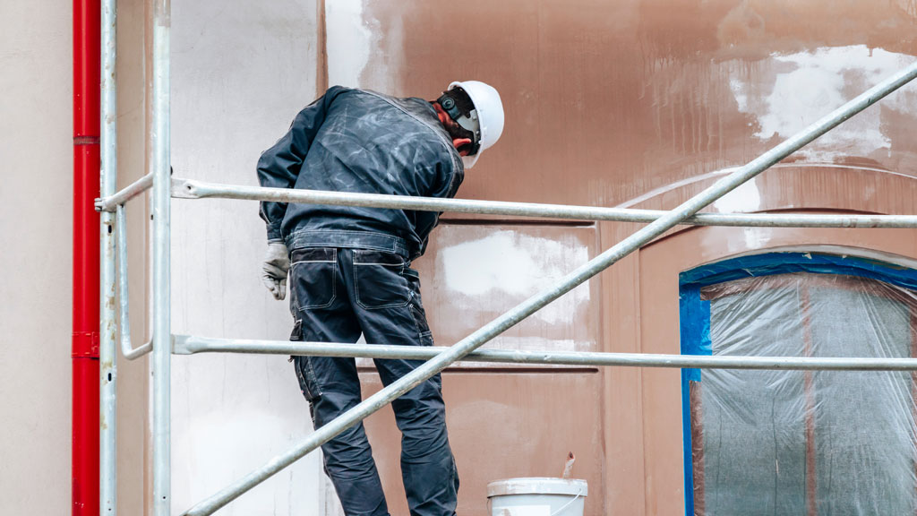 Propriétaire et peintre discutant devant une façade de maison provençale